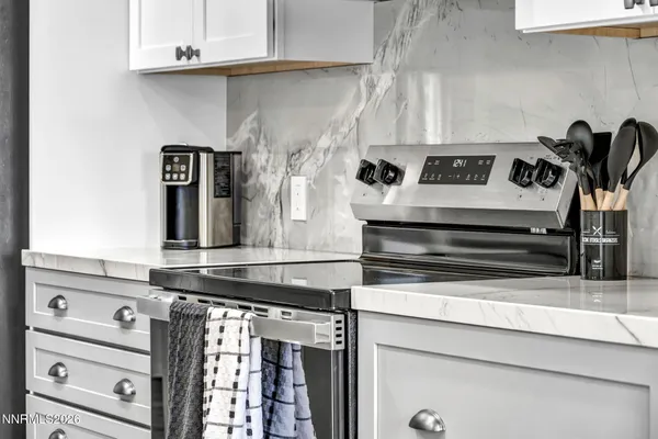 a kitchen with stainless steel appliances a sink a stove and a large window