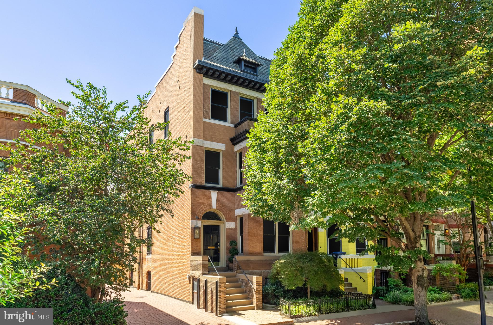 a front view of a building with trees
