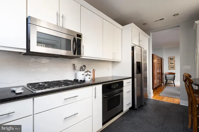a kitchen with stainless steel appliances a stove microwave and cabinets