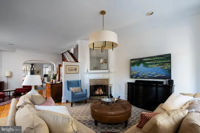 a living room with furniture a fireplace and a chandelier