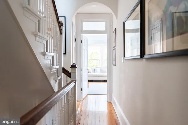 a view of a hallway with wooden floor and staircase