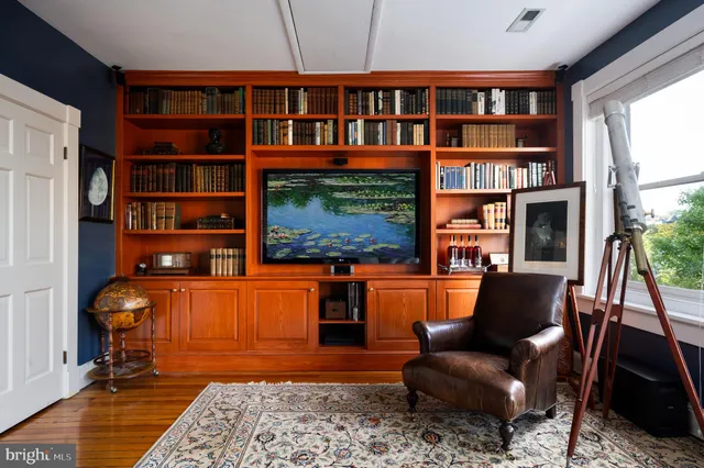 a living room with fireplace furniture and a book shelf