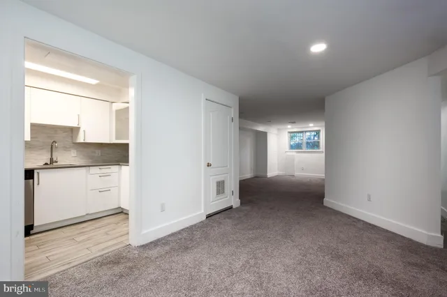 a view of an empty room with window and cabinet
