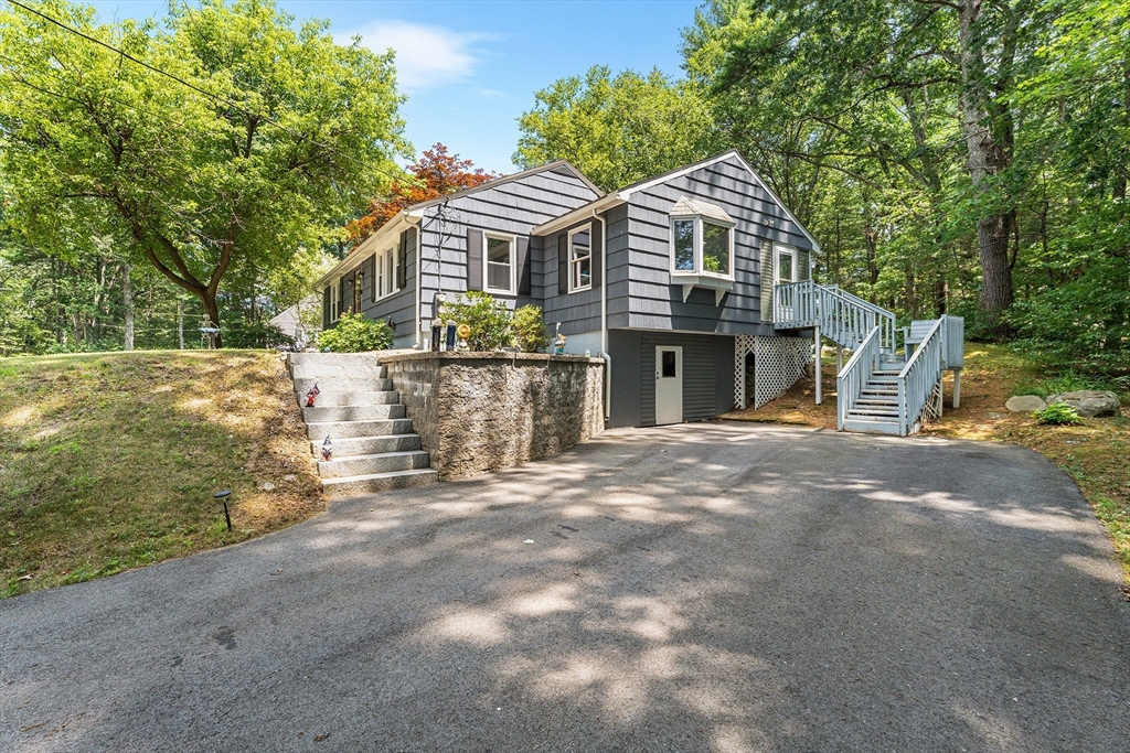 10 Mason Road Holden, MA 01522 - Photo 2 of 27 a front view of a house with a garden and trees