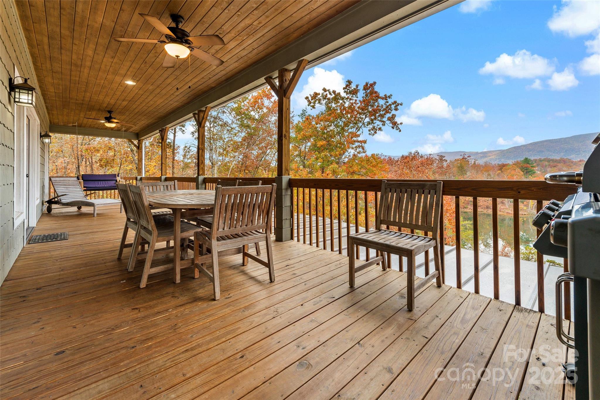 1237 South Cove Road Mill Spring, NC 28756 - Photo 17 of 44 a view of a roof deck with table and chairs with wooden floor and fence