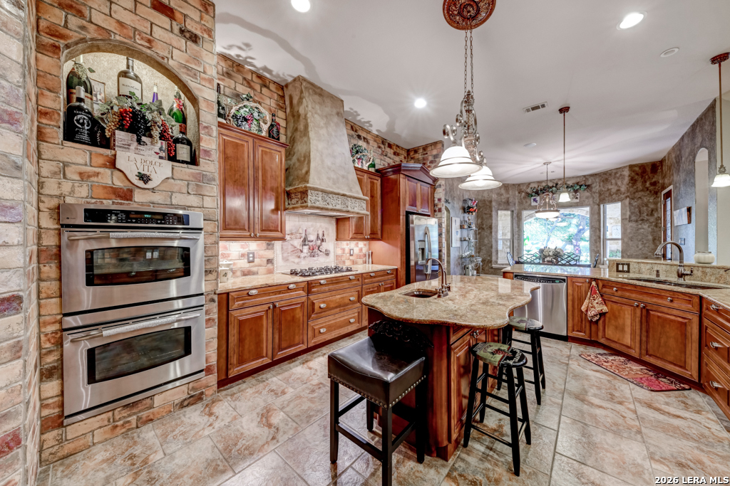 1700 Frontier Spring Branch, TX 78070 - Photo 29 of 74 a kitchen with stainless steel appliances kitchen island granite countertop a stove top oven a sink a dining table and chairs with wooden floor