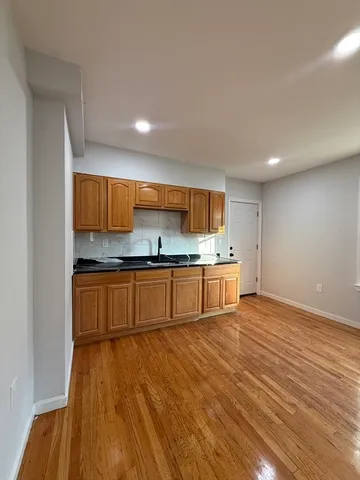 a large kitchen with a lot of counter space and wooden floor