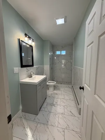 a bathroom with a sink a toilet and shower