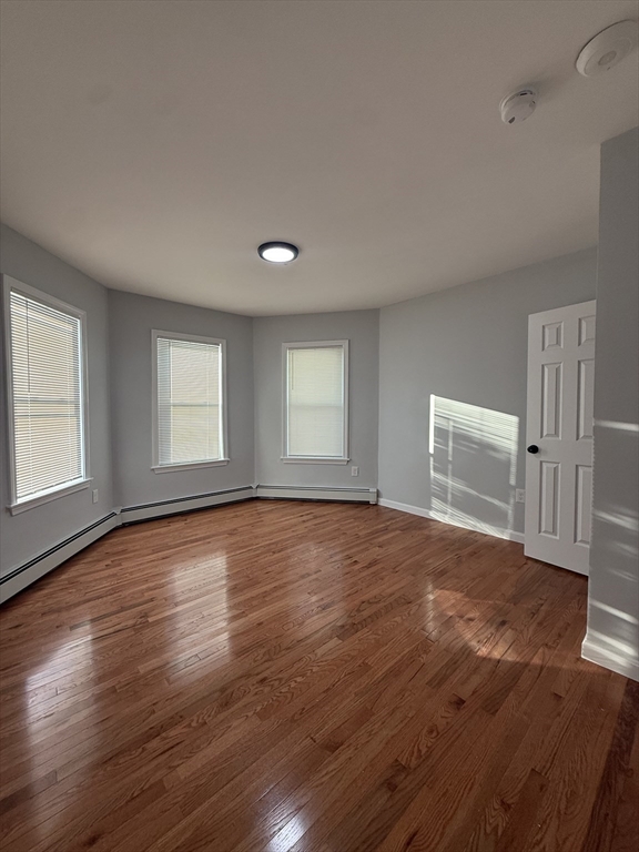 78 Hollis Street, Unit 3 Worcester, MA 01610 - Photo 5 of 9 an empty room with wooden floor and windows