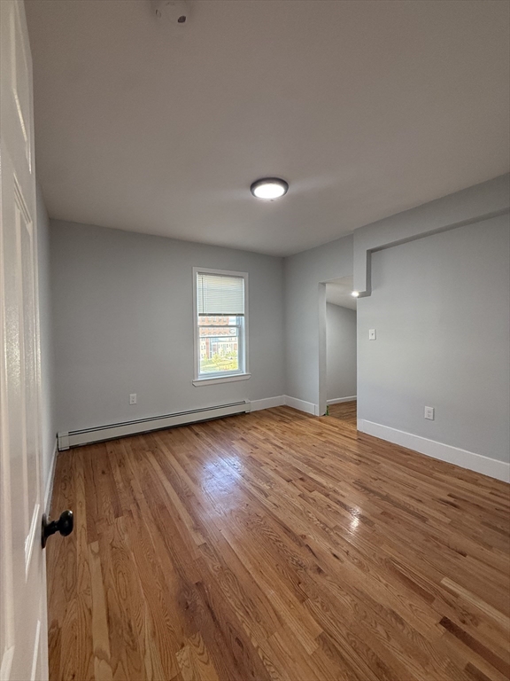 78 Hollis Street, Unit 3 Worcester, MA 01610 - Photo 7 of 9 an empty room with wooden floor and windows