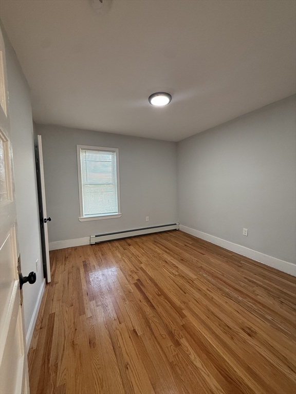 78 Hollis Street, Unit 3 Worcester, MA 01610 - Photo 8 of 9 an empty room with wooden floor and windows
