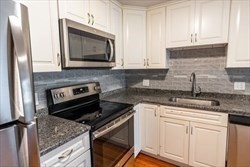 22 Irving Street, Unit 8 Everett, MA 02149 - Photo 3 of 18 a kitchen with granite countertop a stove sink and microwave