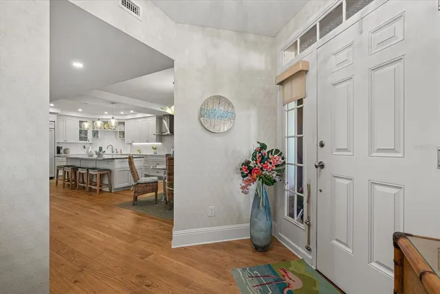 a kitchen with stainless steel appliances kitchen island granite countertop a table chairs sink and cabinets