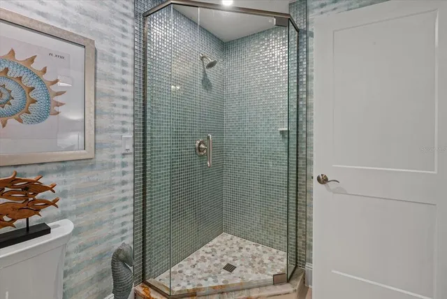 a bathroom with a sink a toilet a shower and a mirror