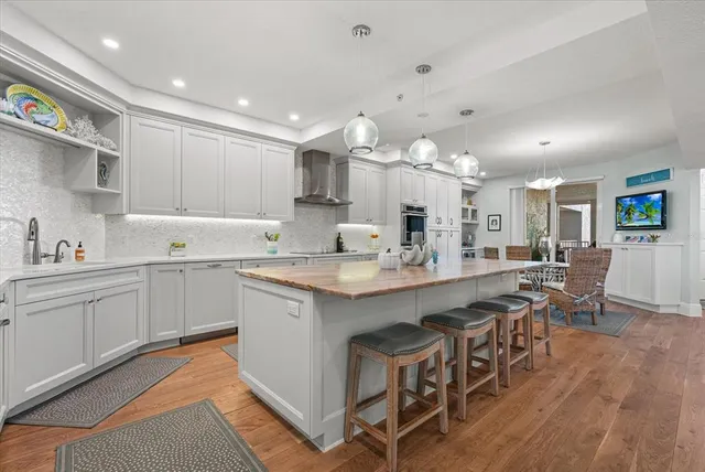 a living room with furniture a flat screen tv and a wooden floor
