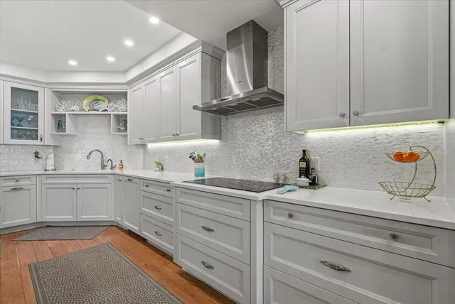 a large white kitchen with kitchen island a sink a center island and cabinets
