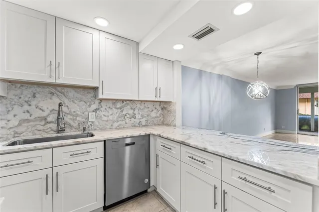 a kitchen with granite countertop white cabinets and white appliances