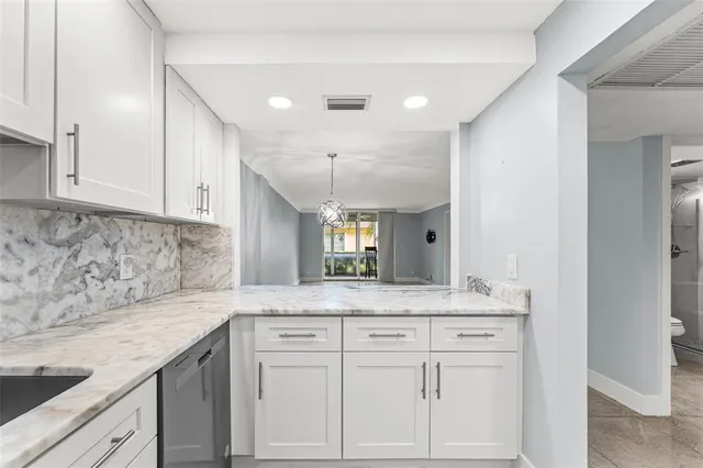 a kitchen with granite countertop white cabinets and a sink