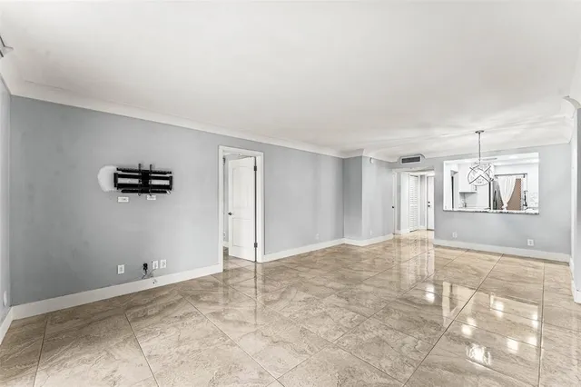 a view of a livingroom with wooden floor and a kitchen space