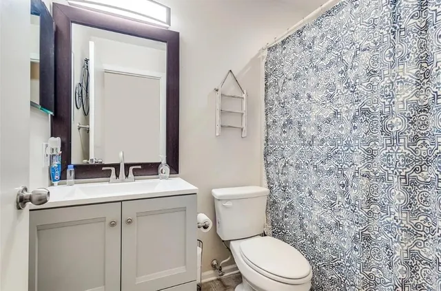 a bathroom with a toilet sink and mirror