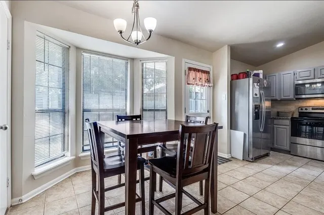 a dining room with furniture a chandelier and wooden floor