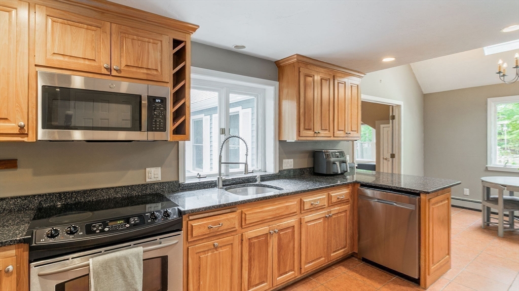 142 Baker Street Walpole, MA 02081 - Photo 10 of 42 a kitchen with stainless steel appliances granite countertop a stove a sink and a microwave