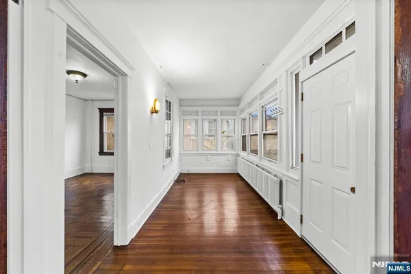 a view of a hallway with wooden floor and staircase