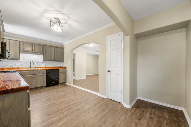 a kitchen with stainless steel appliances granite countertop a sink cabinets and wooden floor