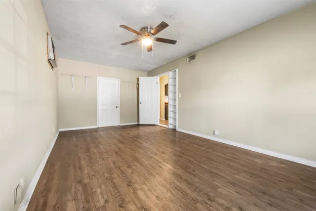 a view of an empty room with wooden floor