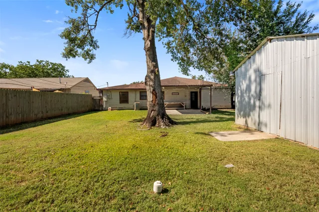a view of a house with backyard and trees