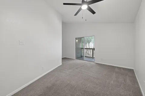 an empty room with chandelier fan