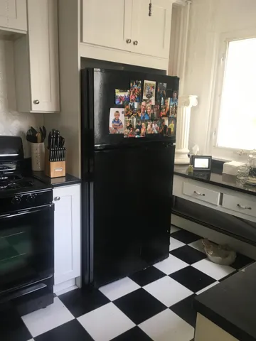 a kitchen with stainless steel appliances kitchen island granite countertop a refrigerator and a stove