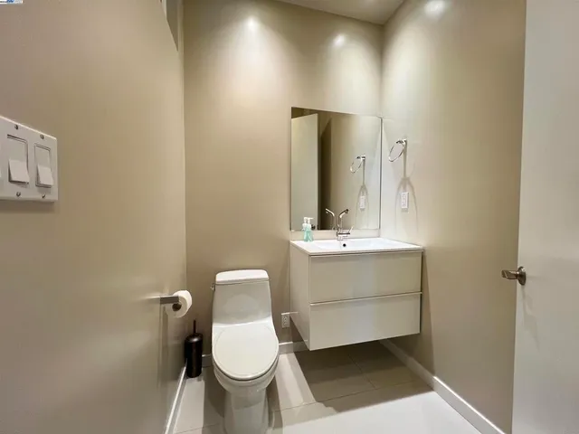 a bathroom with a sink toilet a mirror and vanity