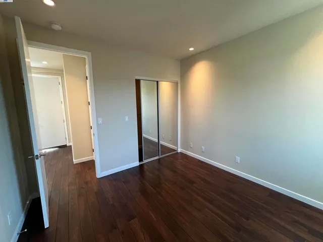 an empty room with wooden floor and entrance