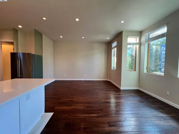 a view of hallway with window and wooden floor