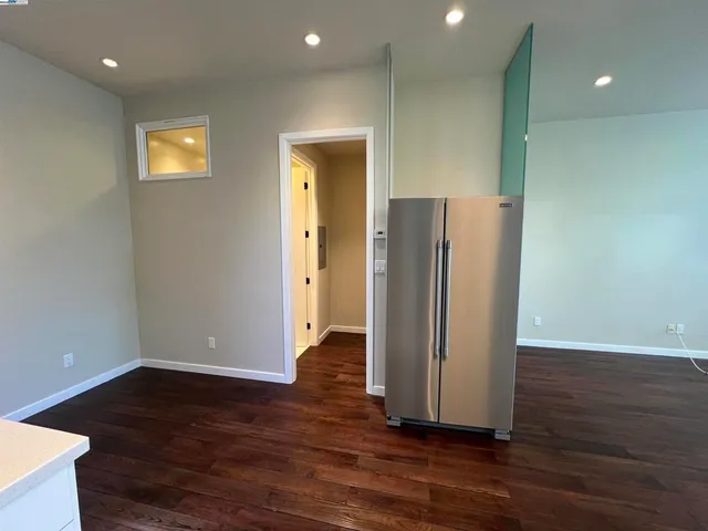 an empty room with wooden floor and a painting