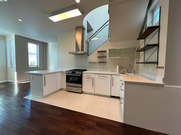 a kitchen with a stove cabinets and wooden floor