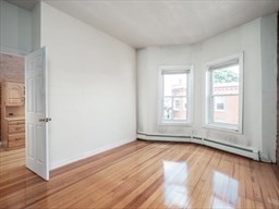 4 Saxton Street Boston, MA 02125 - Photo 4 of 9 an empty room with wooden floor and windows