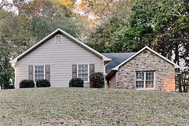 a view of a house with a yard and large tree
