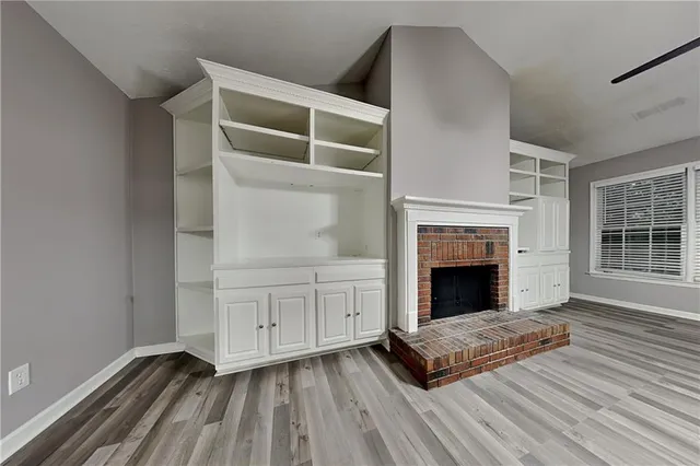 a living room with a fireplace and wooden floor