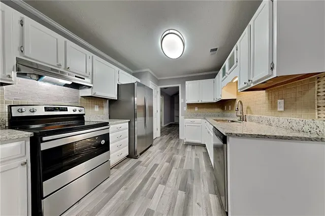 a kitchen with granite countertop stainless steel appliances and wooden cabinets