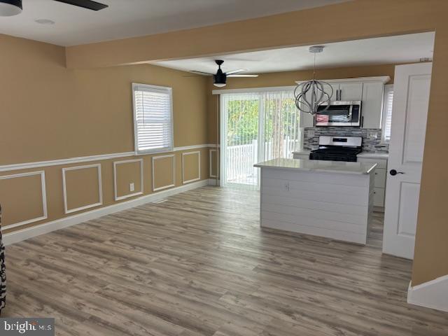 106 Bethel Road Somers Point, NJ 08244 - Photo 15 of 37 a view of a kitchen with kitchen island a sink wooden floor and a large window