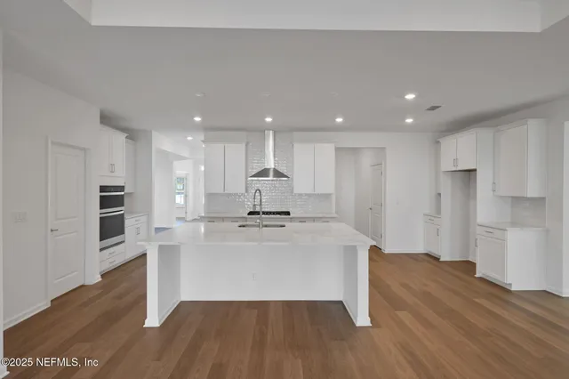 a kitchen with granite countertop a stove a microwave and cabinets