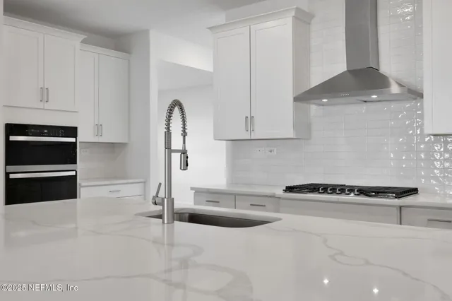 a kitchen with stainless steel appliances granite countertop a sink a stove and a refrigerator