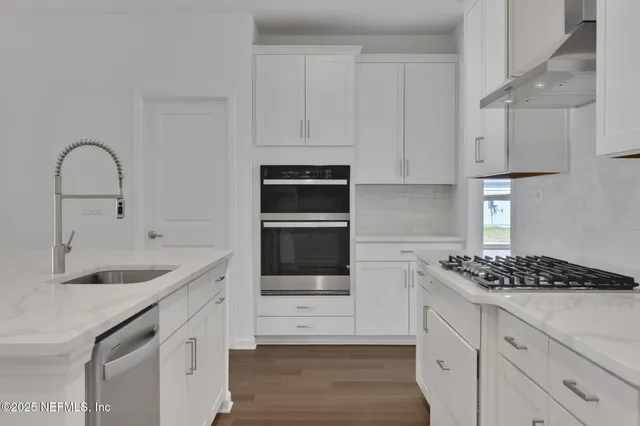 a view of a kitchen with a sink and a refrigerator