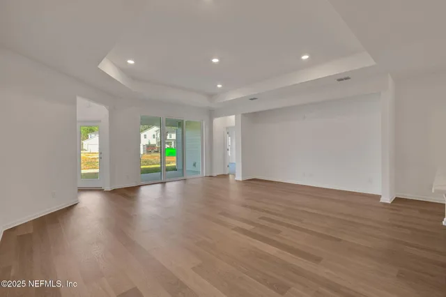 a view of kitchen with kitchen island wooden floor center island and stainless steel appliances