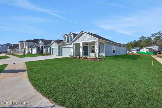 a view of a house with a big yard and large trees