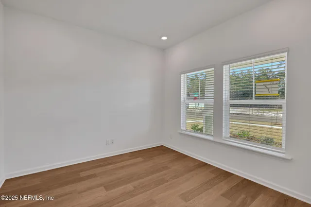 a view of an empty room with wooden floor