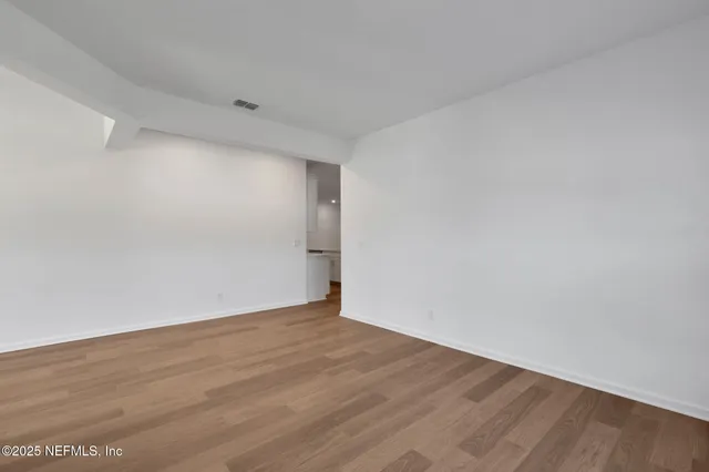 a large kitchen with a center island wooden floor stainless steel appliances and cabinets