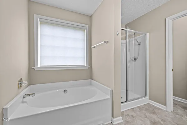 a white bath tub sitting next to a shower